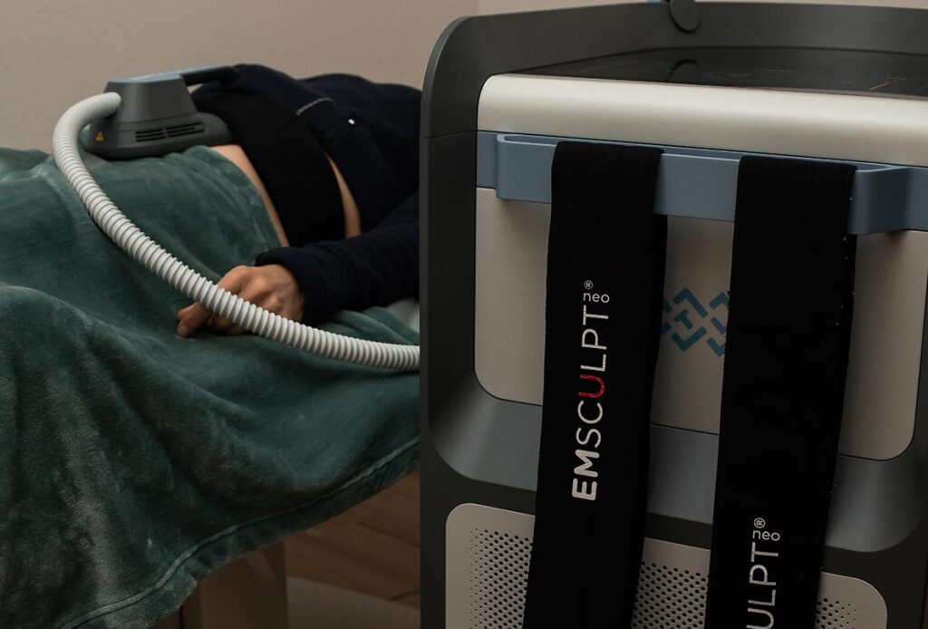 Emsculpt machine next to man receiving treatment in Laramie, WY
