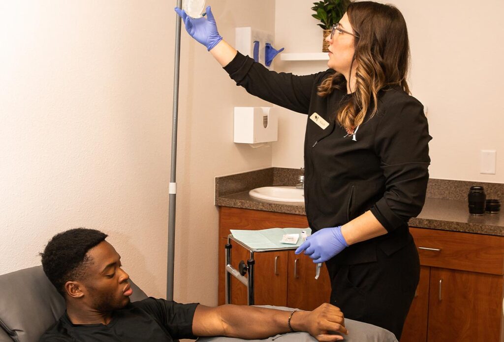 Nurse providing IV therapy to man at Ascent Med Spa