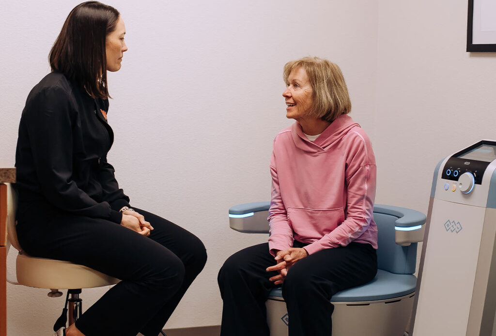 Dr. Kim Westbrook in a consultation with a woman on the Emsella Chair