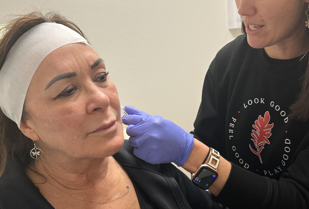 Patient tilting her head receiving Sculptra by Dr. Kim Westbrook