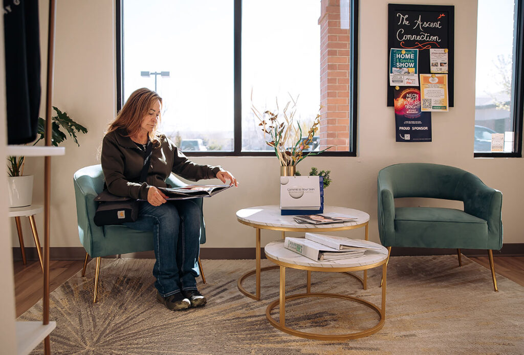 Woman reading a magazine in the lobby of Ascent Med Spa